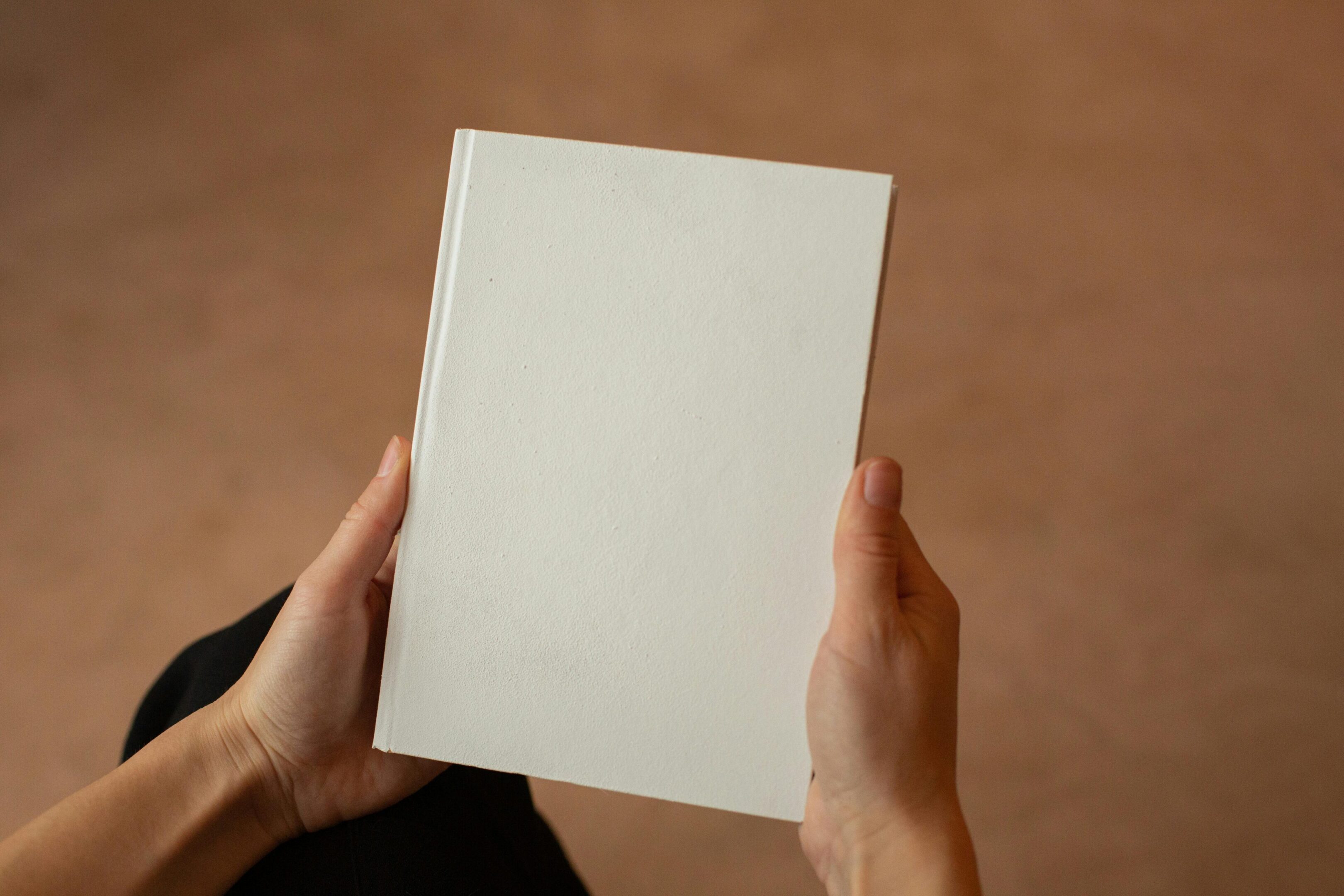 A person holding an empty book in their hands.