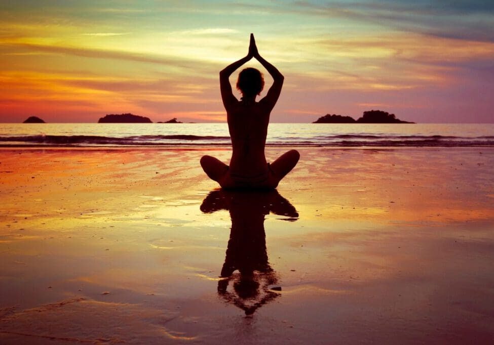 A person is sitting in the water doing yoga.