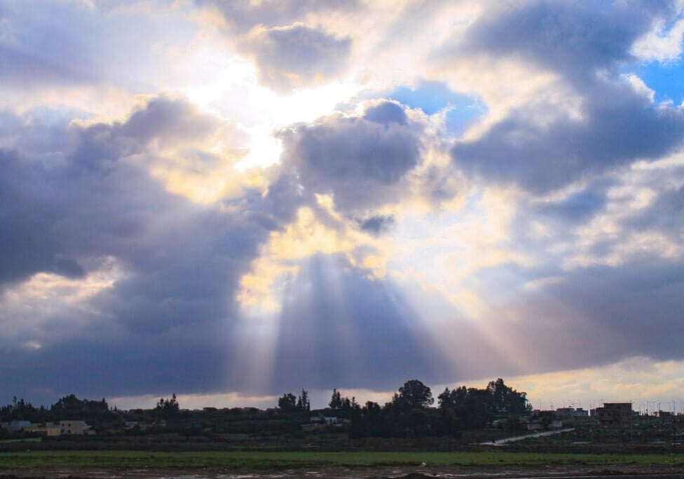 A view of the sky with sun rays coming through.